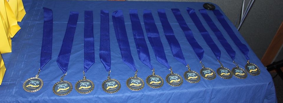 Fifteen Successful 75 medallions lying on a table.